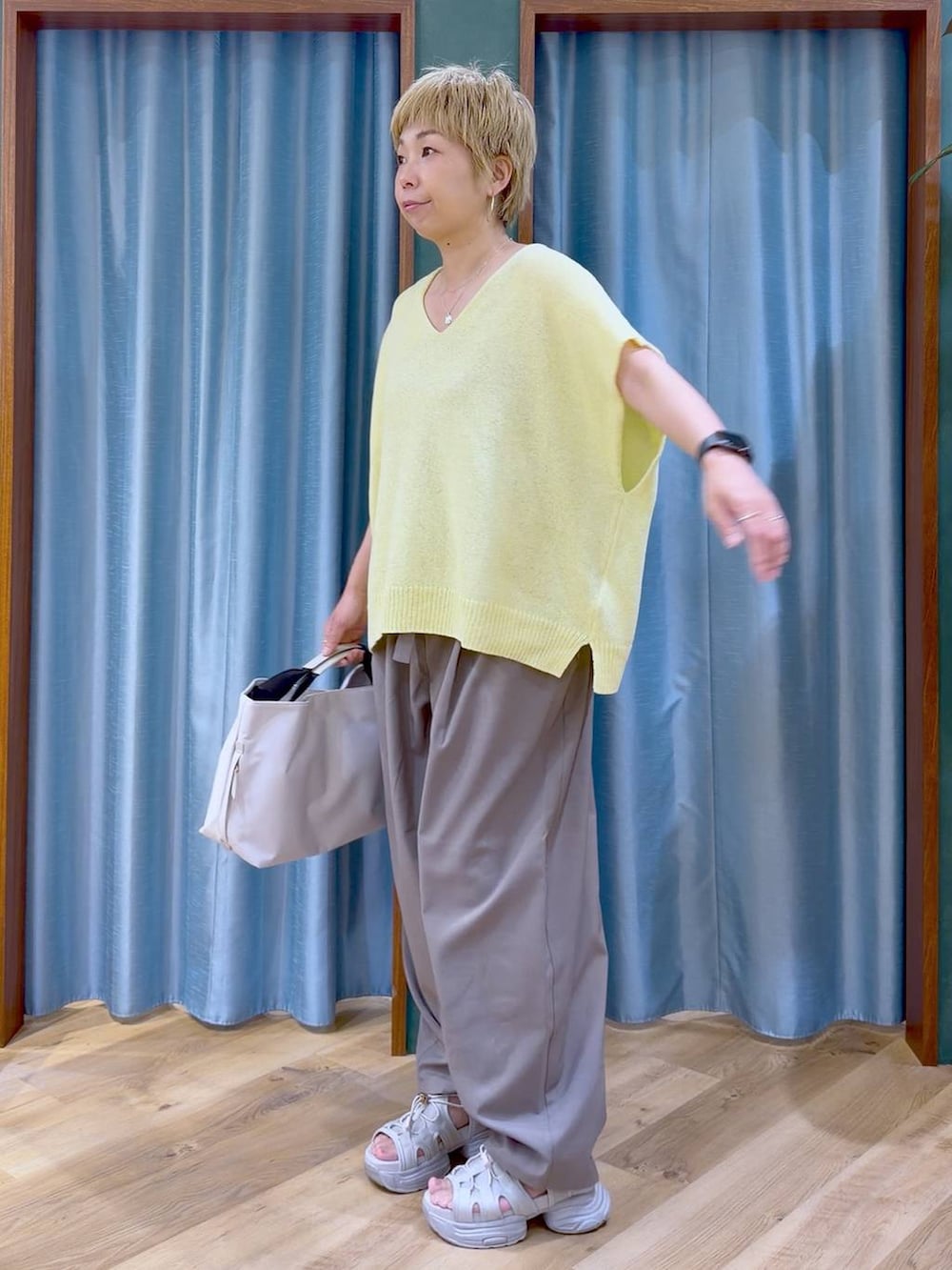 ホワイト系のトートバッグ、グレー系のサンダル、ブラウン系のその他パンツを着用したレディースの夏コーディネートの4枚目の写真