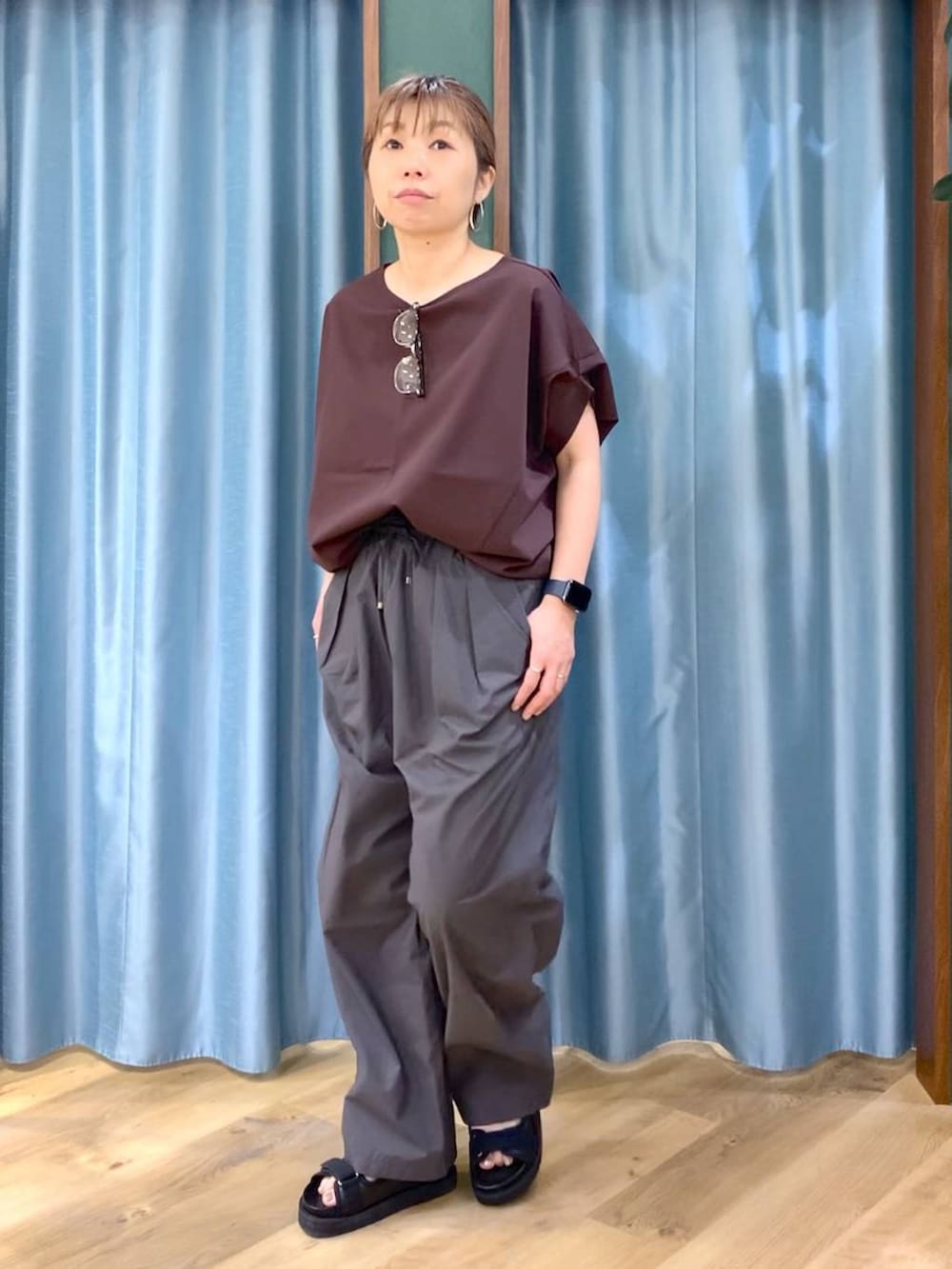 グレー系のその他パンツ、ブラウン系のTシャツ/カットソー、ブラック系のサンダルを着用したレディースの春コーディネートの3枚目の写真