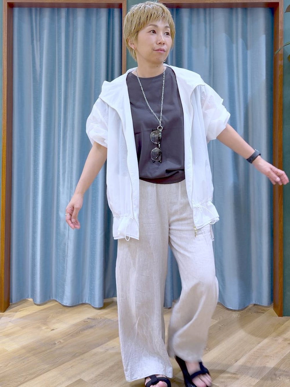ベージュ系のその他パンツ、ホワイト系のブルゾン、ブラック系のサンダルを着用したレディースの夏コーディネートの5枚目の写真