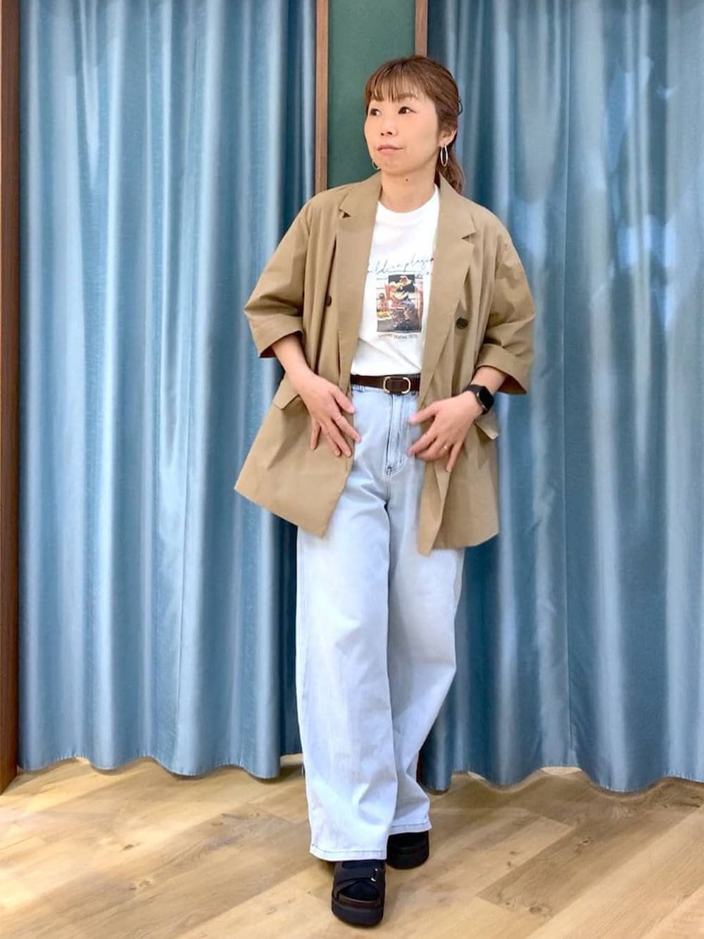 ブルー系のデニムパンツ、ホワイト系のTシャツ/カットソー、ブラウン系のサンダルを着用したレディースの春コーディネートの2枚目の写真