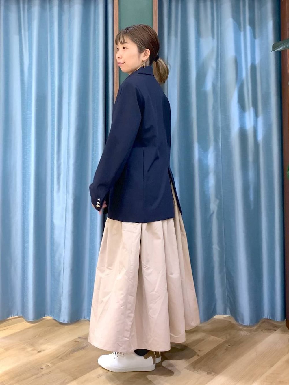 ベージュ系のスカート、ブルー系のテーラードジャケット、ベージュ系のトートバッグを着用したレディースの冬コーディネートの6枚目の写真