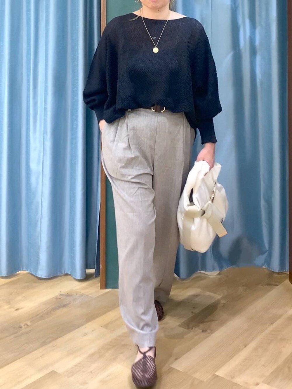 ブラック系のニット/セーター、ベージュ系のその他パンツ、ホワイト系のトートバッグを着用したレディースの春コーディネートの7枚目の写真