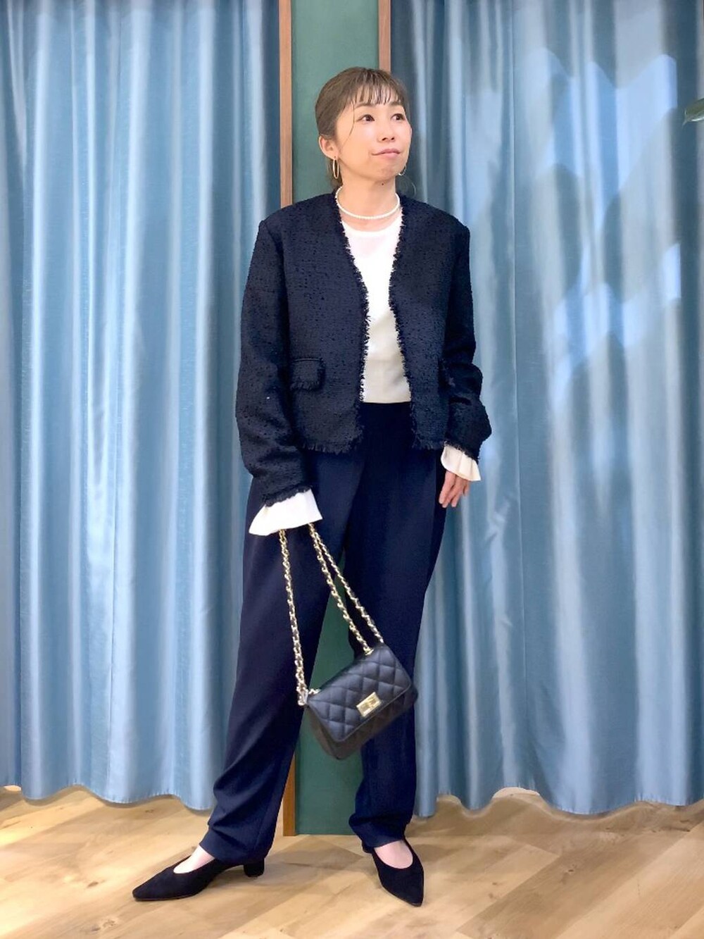 ホワイト系のニット/セーター、ブラック系のノーカラージャケット、ブルー系のその他パンツを着用したレディースの冬コーディネートの2枚目の写真