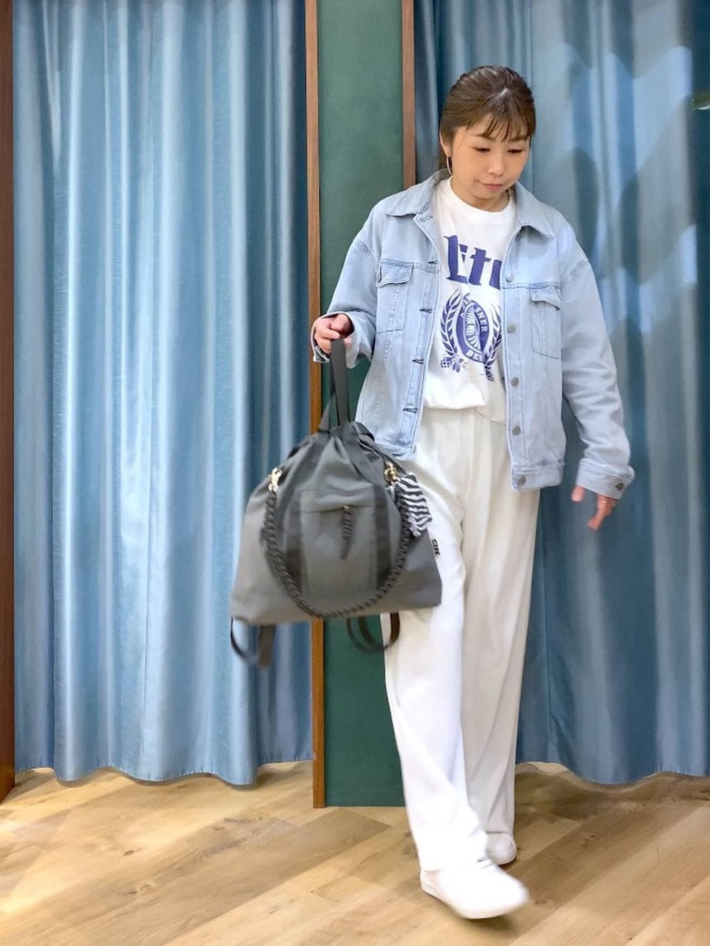 ホワイト系のスラックス、ブルー系のデニムジャケット、ホワイト系のTシャツ/カットソーを着用したレディースの冬コーディネートの3枚目の写真