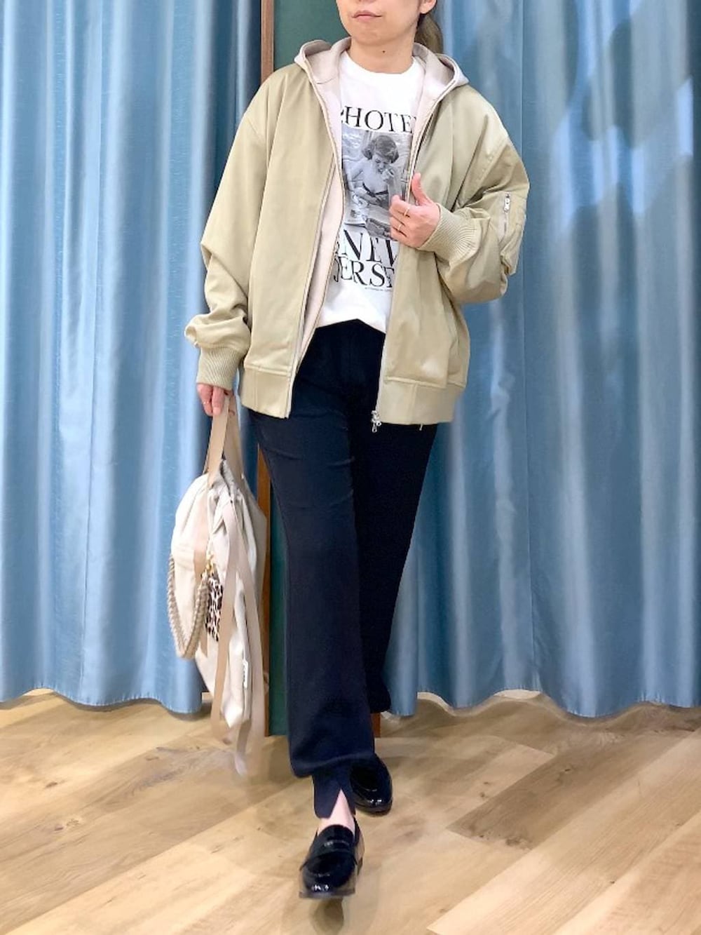 ベージュ系のパーカー、グリーン系のMA-1、ホワイト系のTシャツ/カットソーを着用したレディースの冬コーディネートの6枚目の写真