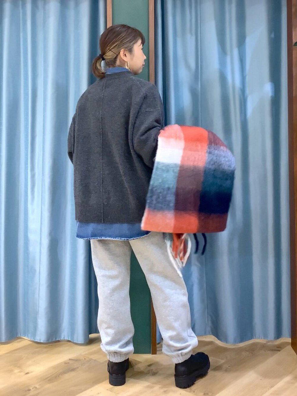 ブラック系のブーツ、ブルー系のシャツ/ブラウス、グレー系のニット/セーターを着用したレディースの秋コーディネートの3枚目の写真