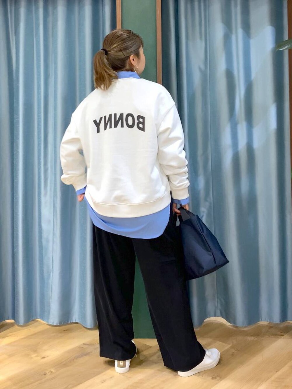 ブラック系のスラックス、ブルー系のトートバッグ、ブルー系のシャツ/ブラウスを着用したレディースの冬コーディネートの3枚目の写真