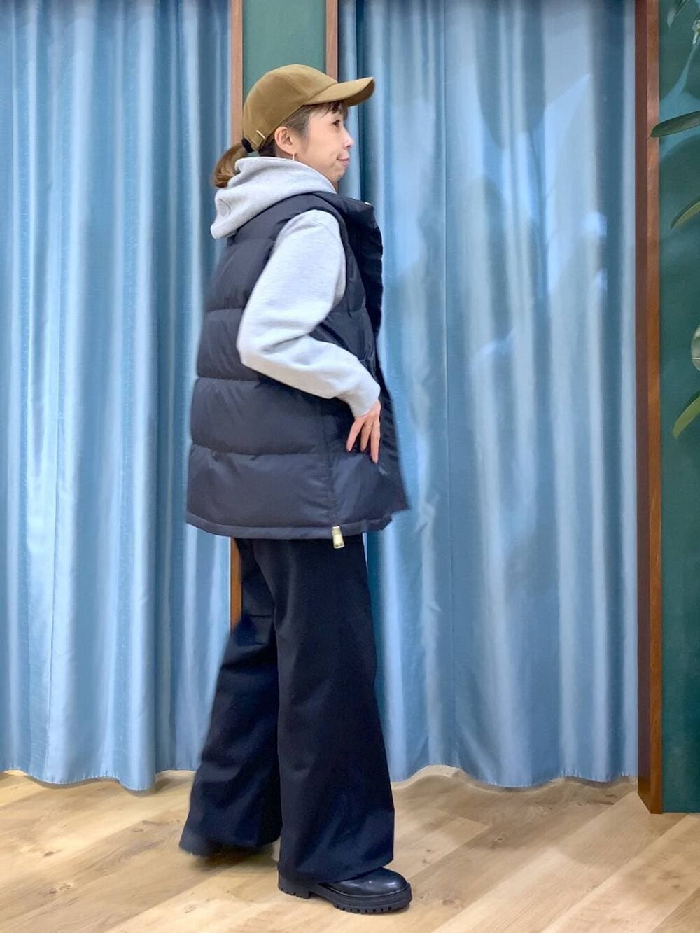 ブラック系のブーツ、グレー系のパーカー、ブラック系のダウンベストを着用したレディースの冬コーディネートの2枚目の写真