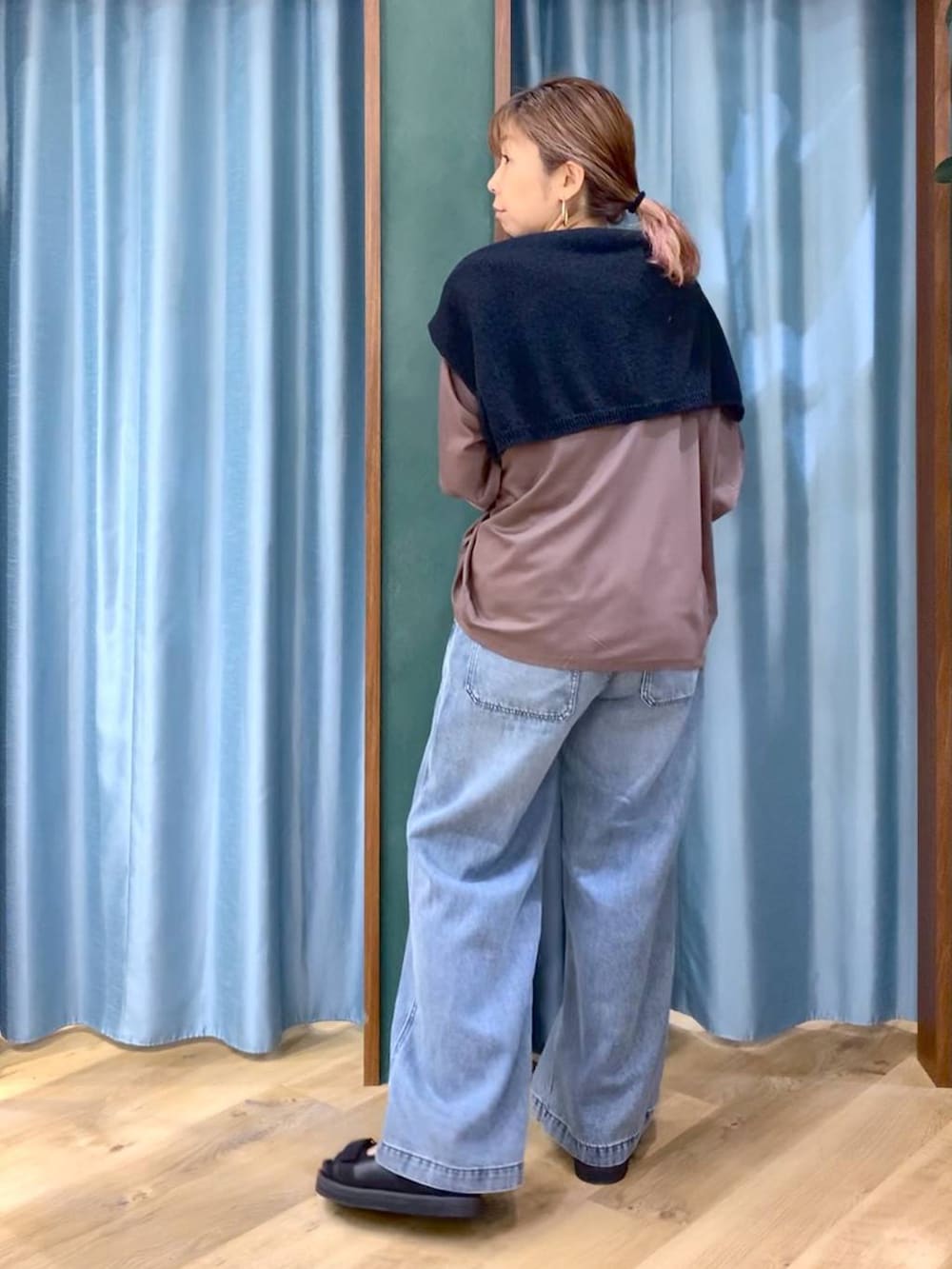 ブラウン系のTシャツ/カットソー、ブルー系のデニムパンツ、ブラック系のニット/セーターを着用したレディースの春コーディネートの6枚目の写真