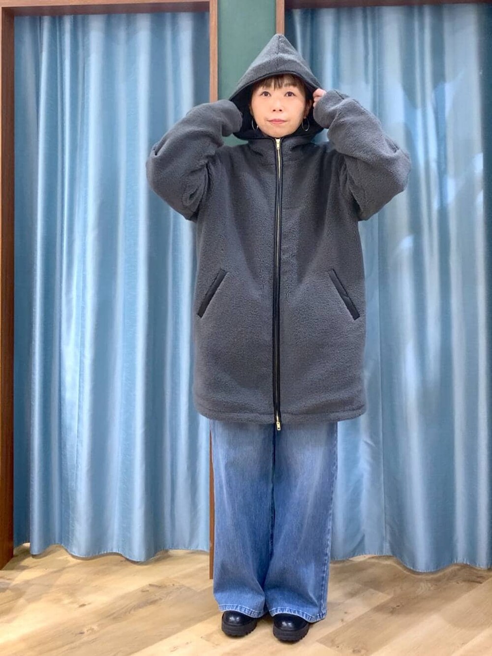 ブラック系のブーツ、ブルー系のデニムパンツ、ブルー系のニット/セーターを着用したレディースの冬コーディネートの9枚目の写真