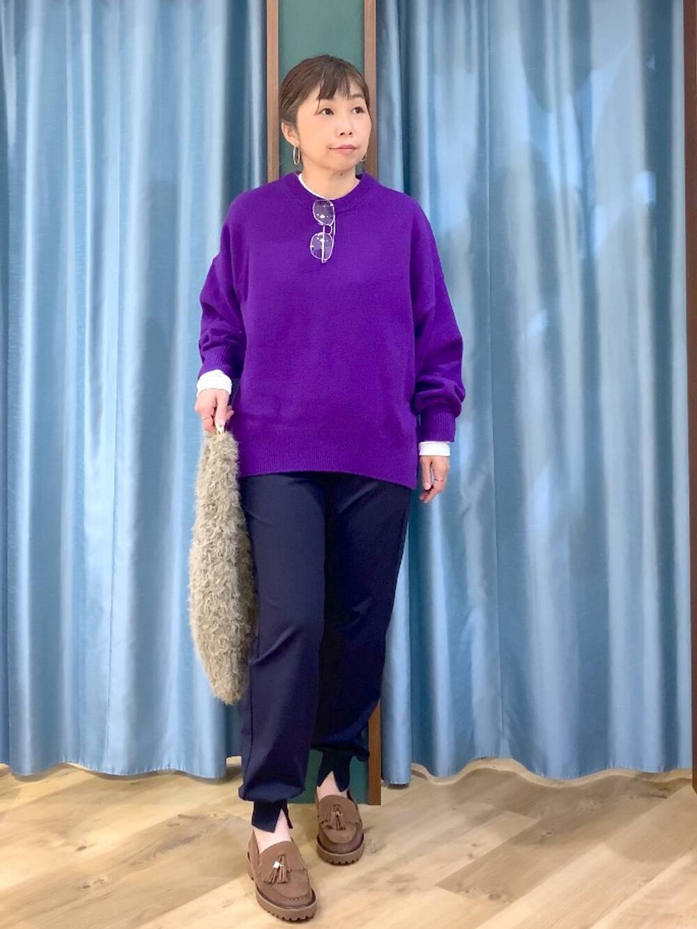 パープル系のニット/セーター、ベージュ系のハンドバッグ、ブルー系のその他パンツを着用したレディースの秋コーディネートの5枚目の写真