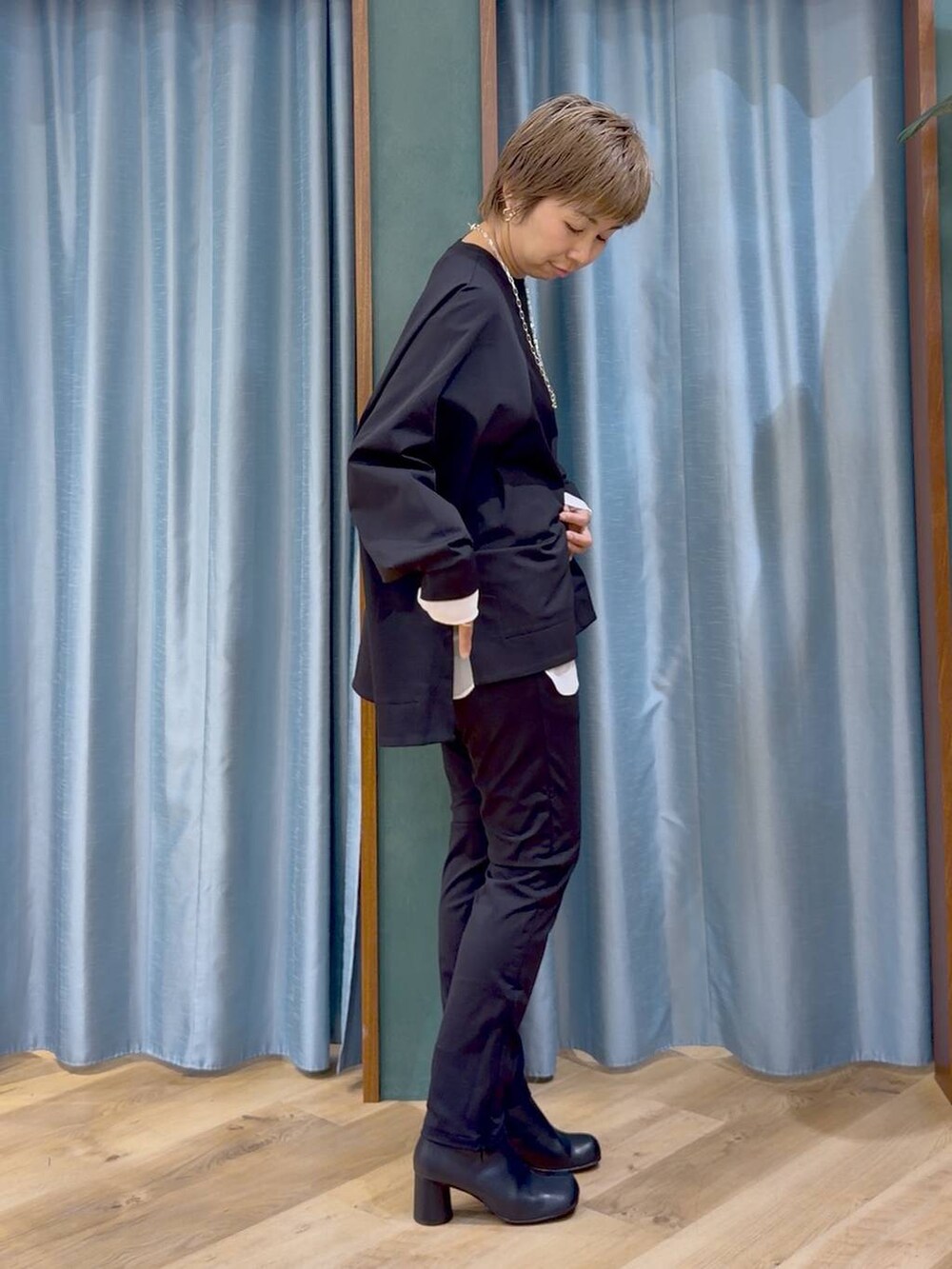 ブラック系のその他パンツ、ブラック系のブーツ、ホワイト系のTシャツ/カットソーを着用したレディースの秋コーディネートの6枚目の写真