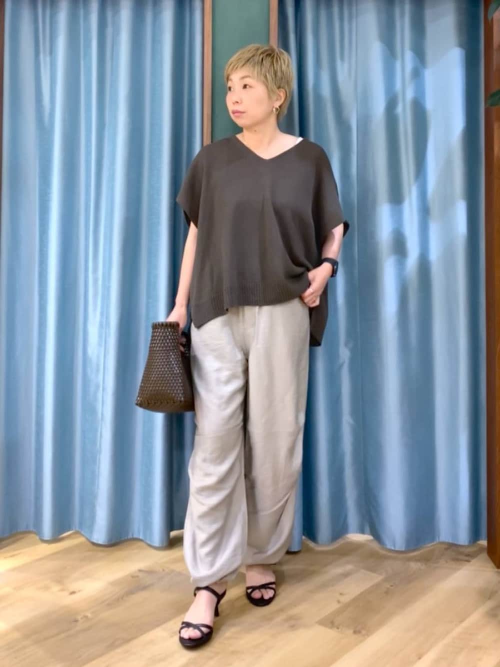 ブラック系のサンダル、ベージュ系のその他パンツ、ブラウン系のハンドバッグを着用したレディースの夏コーディネートの2枚目の写真