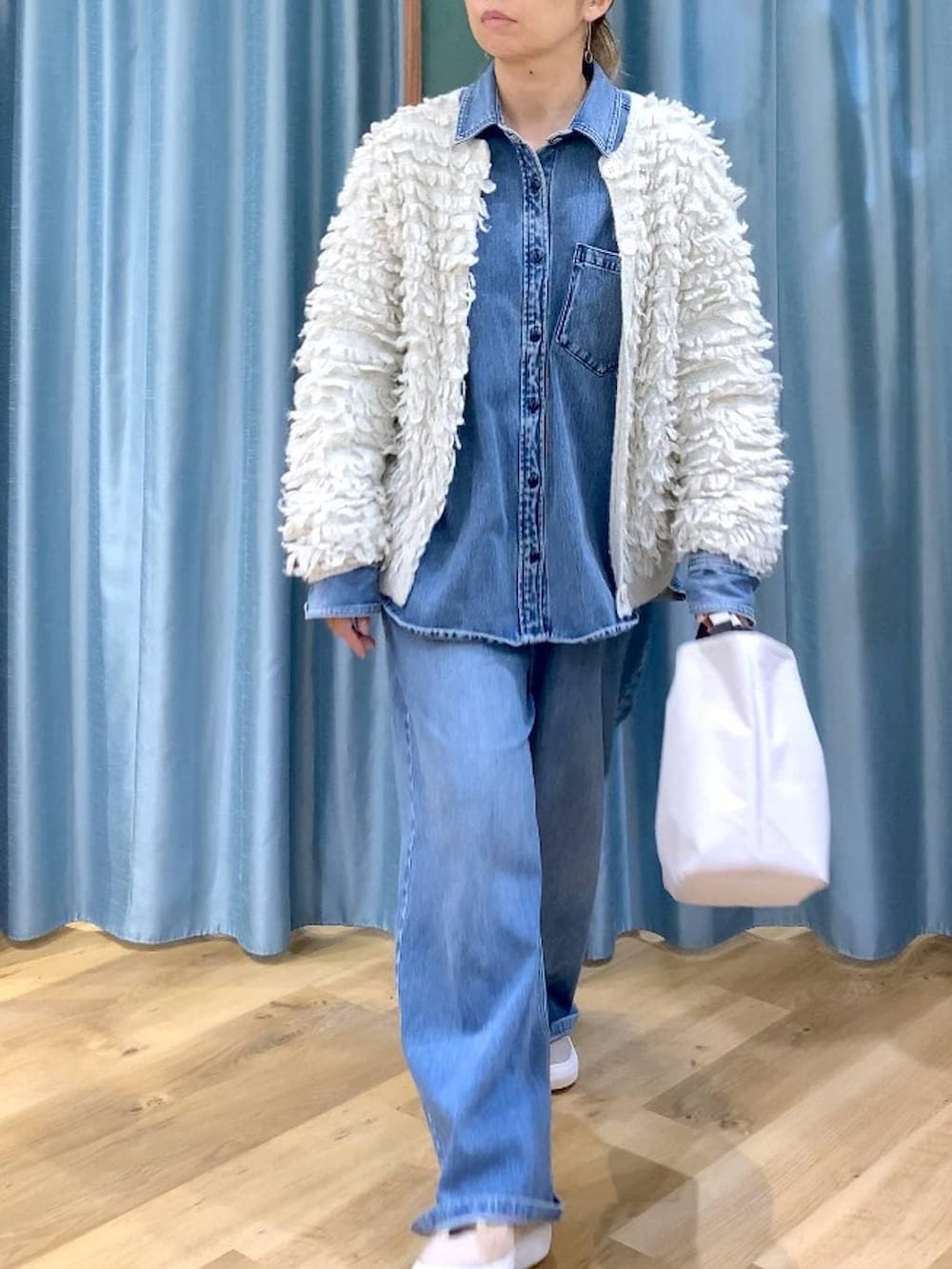 ブルー系のシャツ/ブラウス、ブルー系のデニムパンツ、ベージュ系のスニーカーを着用したレディースの冬コーディネートの6枚目の写真