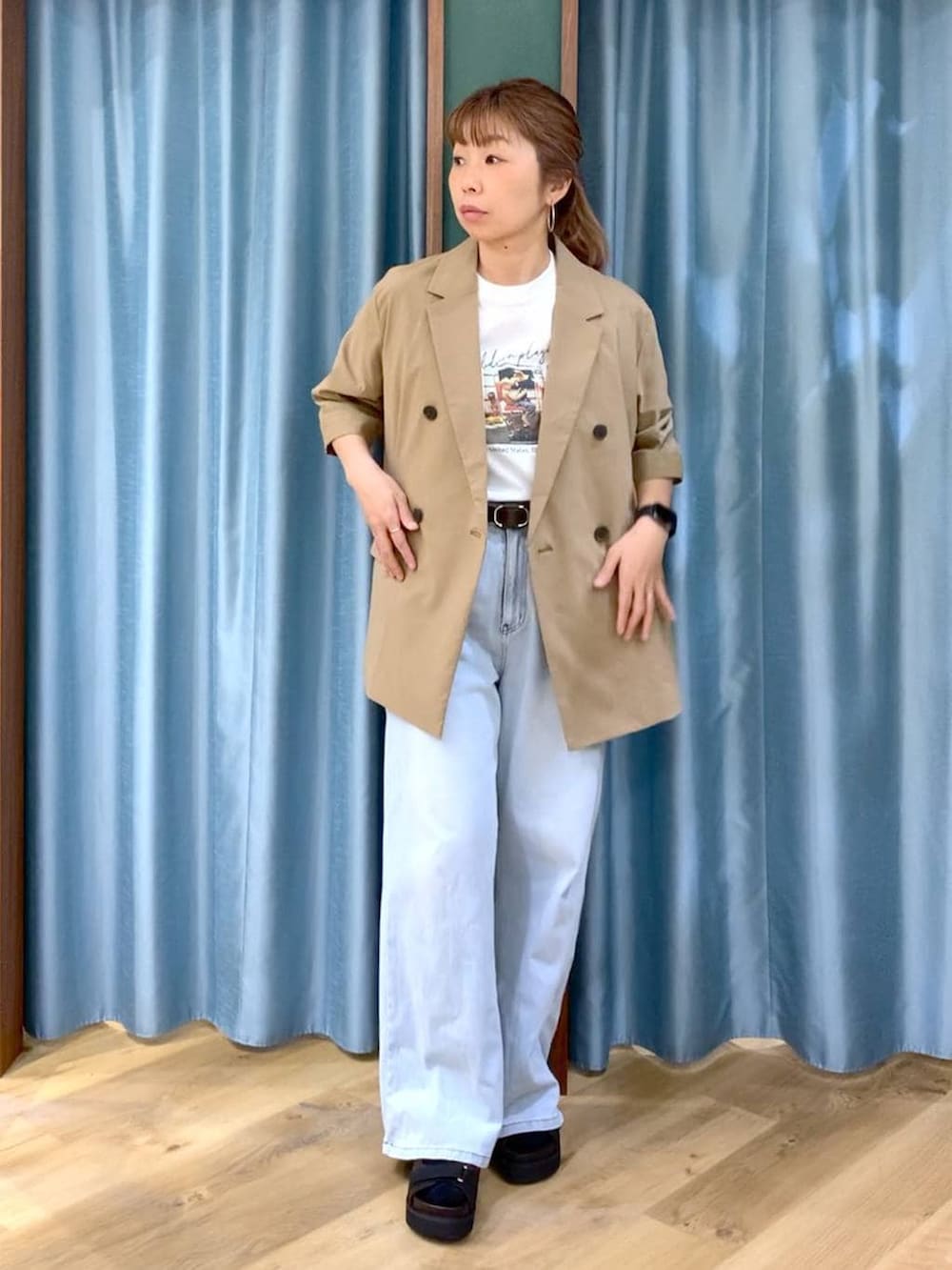 ブルー系のデニムパンツ、ホワイト系のTシャツ/カットソー、ブラウン系のサンダルを着用したレディースの春コーディネートの3枚目の写真