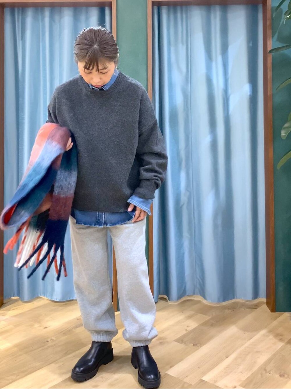 ブラック系のブーツ、ブルー系のシャツ/ブラウス、グレー系のニット/セーターを着用したレディースの秋コーディネートの8枚目の写真