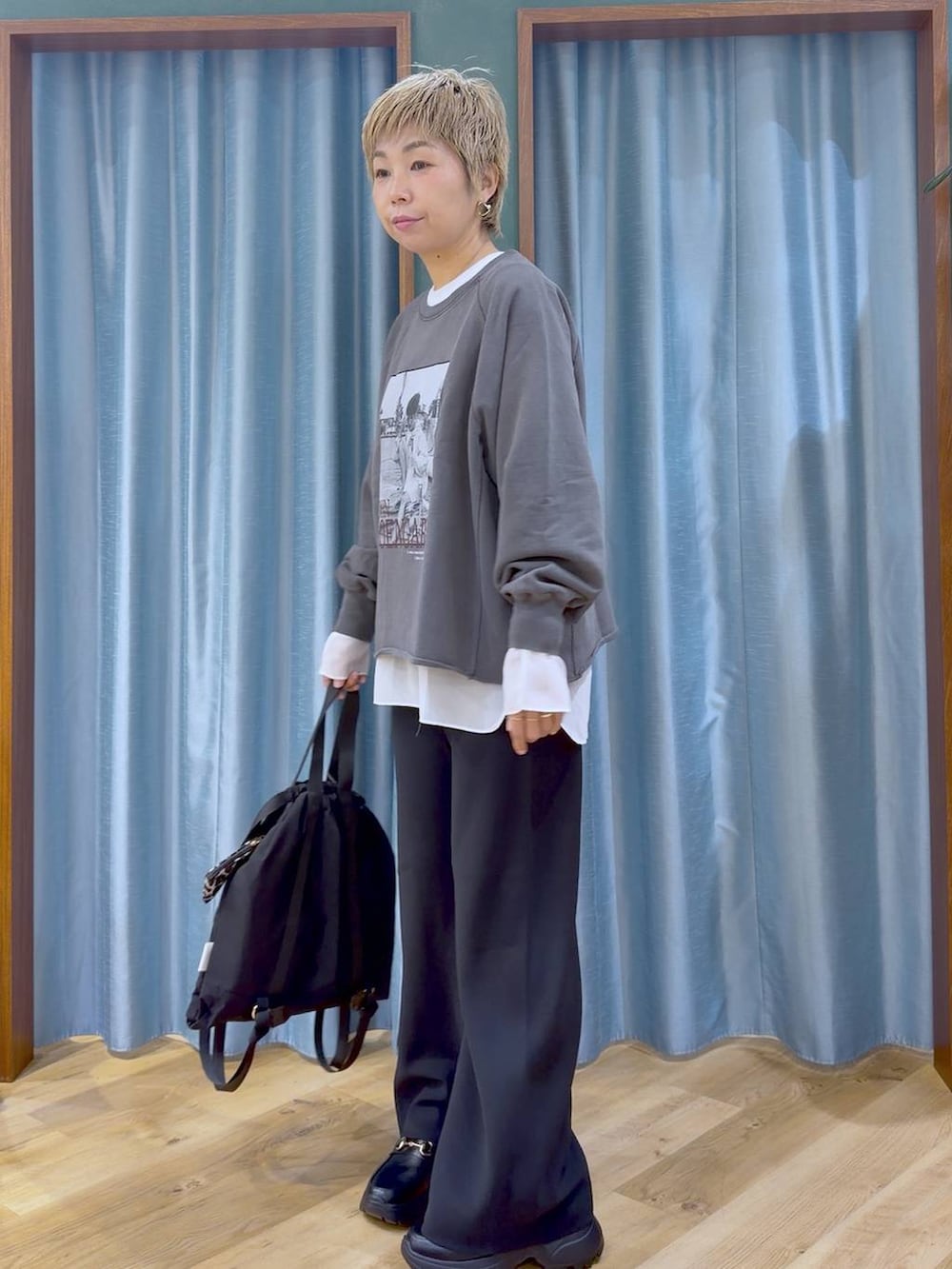 グレー系のスウェット、ブラック系のスニーカー、ホワイト系のTシャツ/カットソーを着用したレディースの秋コーディネートの5枚目の写真