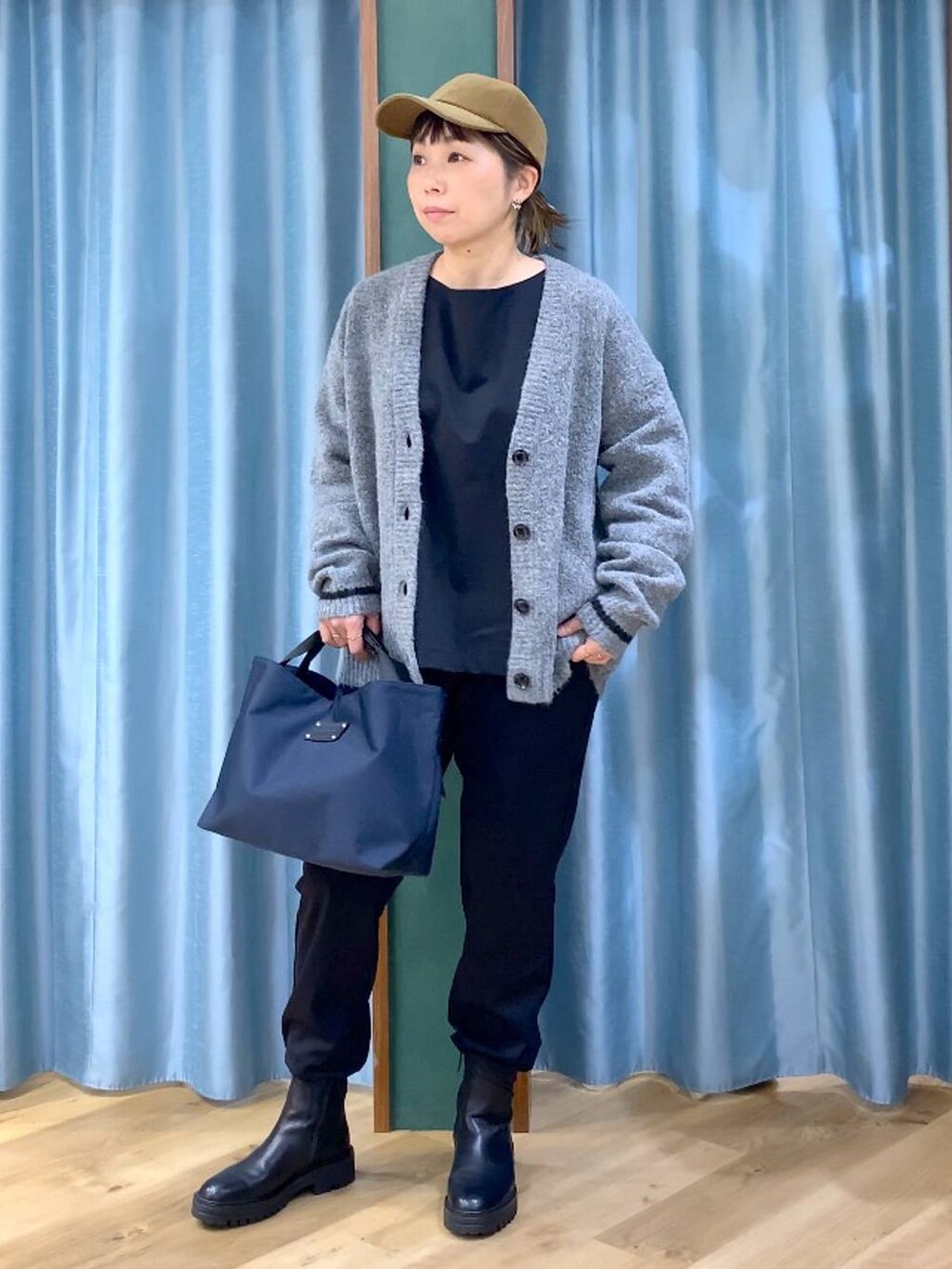 ブラック系のブーツ、ブルー系のトートバッグ、ブラック系のシャツ/ブラウスを着用したレディースの秋コーディネートの2枚目の写真