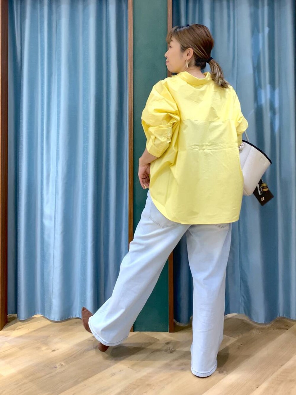 ブラウン系のパンプス、ブルー系のデニムパンツ、イエロー系のシャツ/ブラウスを着用したレディースの春コーディネートの6枚目の写真