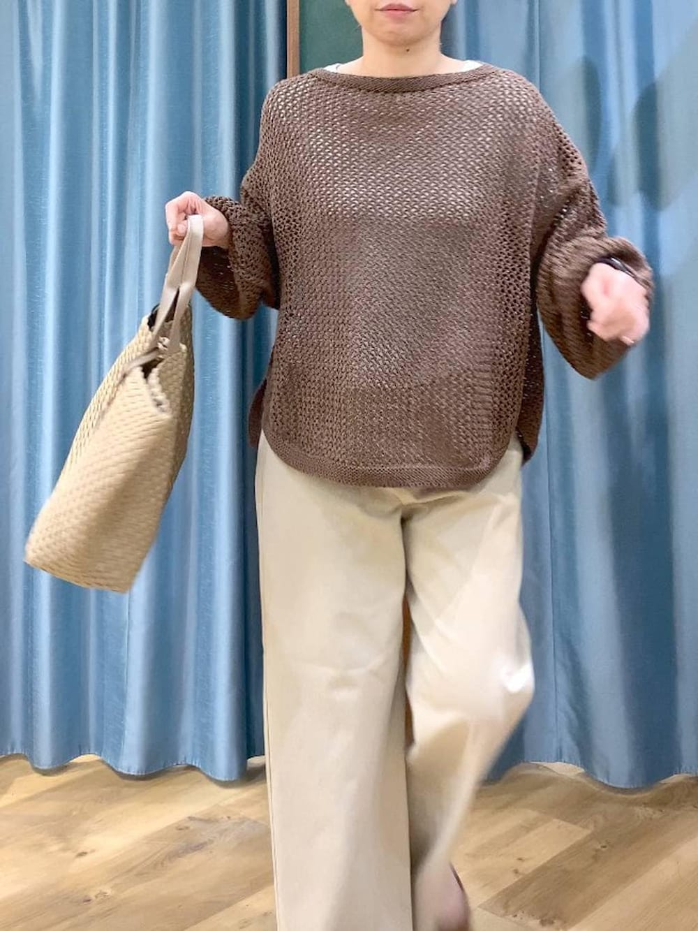 ブラウン系のニット/セーター、ホワイト系のTシャツ/カットソー、ベージュ系のデニムパンツを着用したレディースの冬コーディネートの8枚目の写真