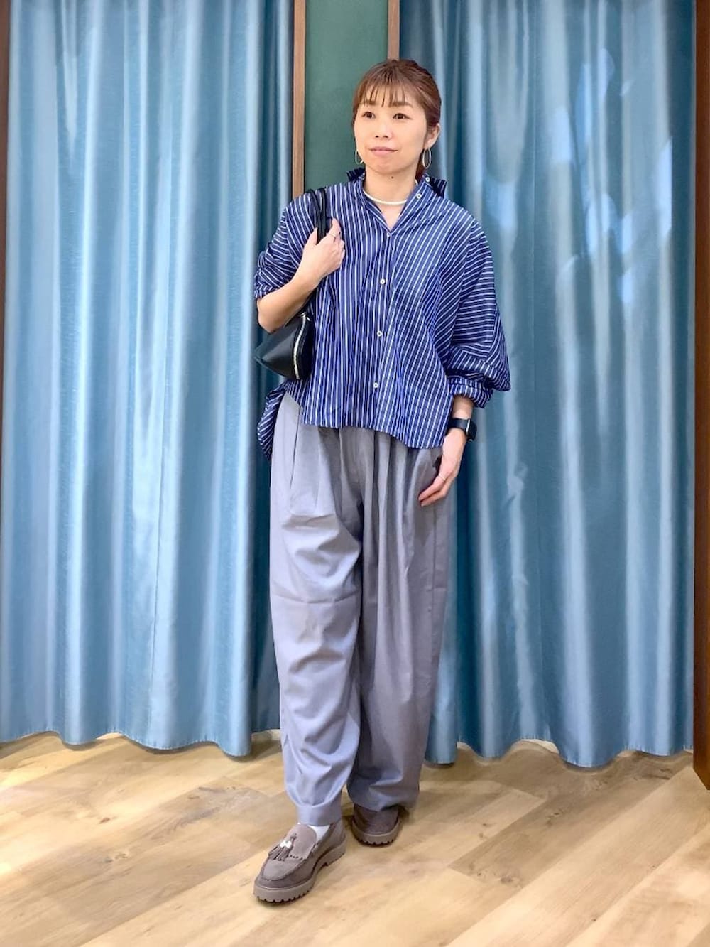 グレー系のローファー、グレー系のその他パンツ、ブルー系のシャツ/ブラウスを着用したレディースの春コーディネートの3枚目の写真