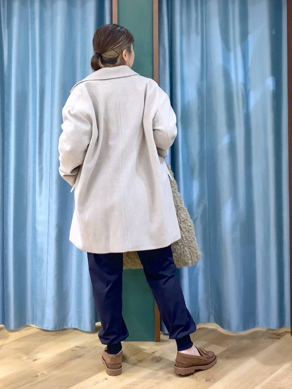 パープル系のニット/セーター、ベージュ系のピーコート、ベージュ系のハンドバッグを着用したレディースの秋コーディネートの6枚目の写真