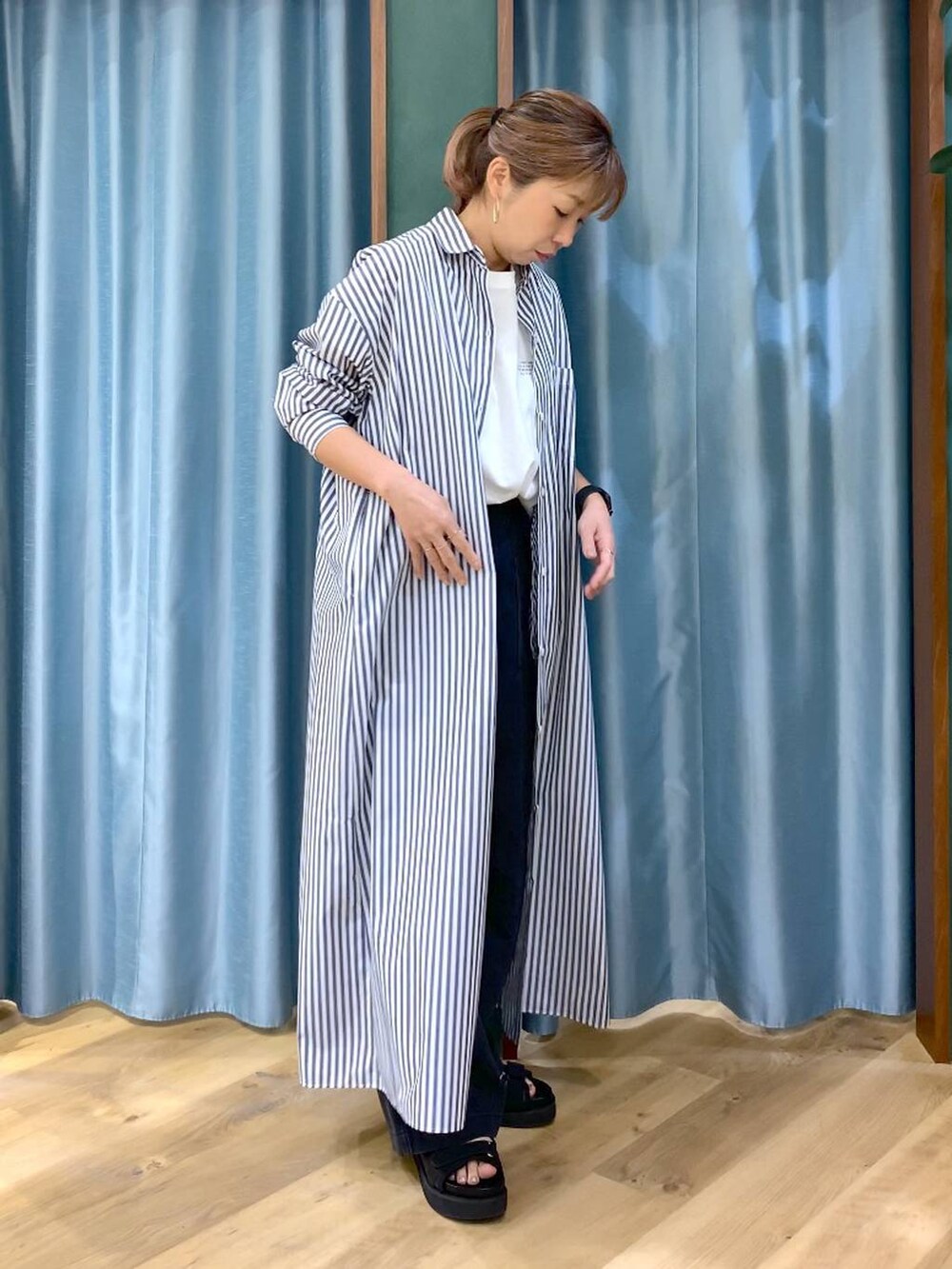 ホワイト系のTシャツ/カットソー、ブルー系のワンピース、グレー系のデニムパンツを着用したレディースの春コーディネートの6枚目の写真