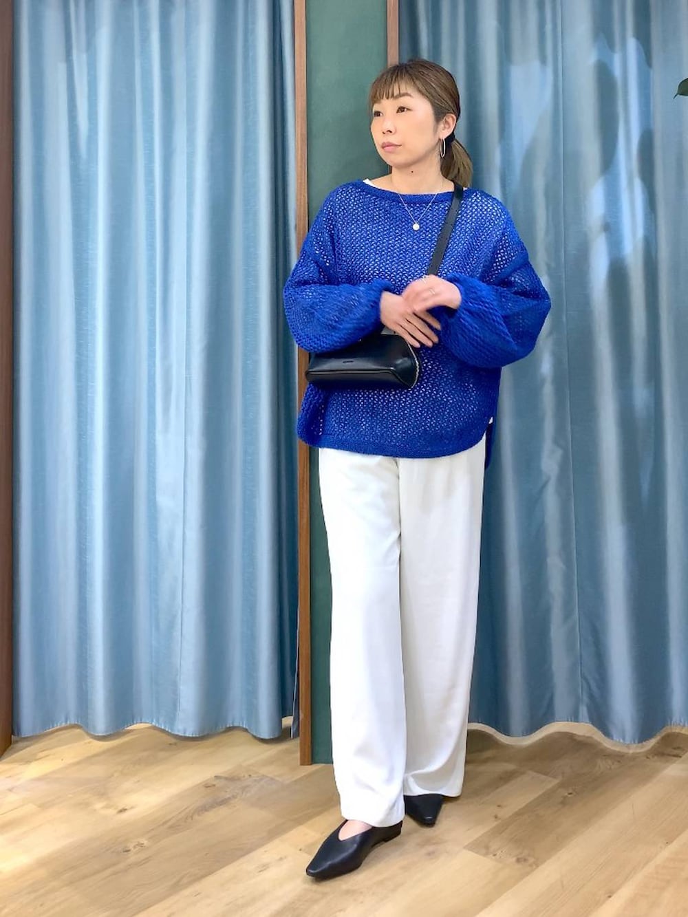 ホワイト系のスラックス、ブルー系のニット/セーター、ブラック系のパンプスを着用したレディースの冬コーディネートの3枚目の写真