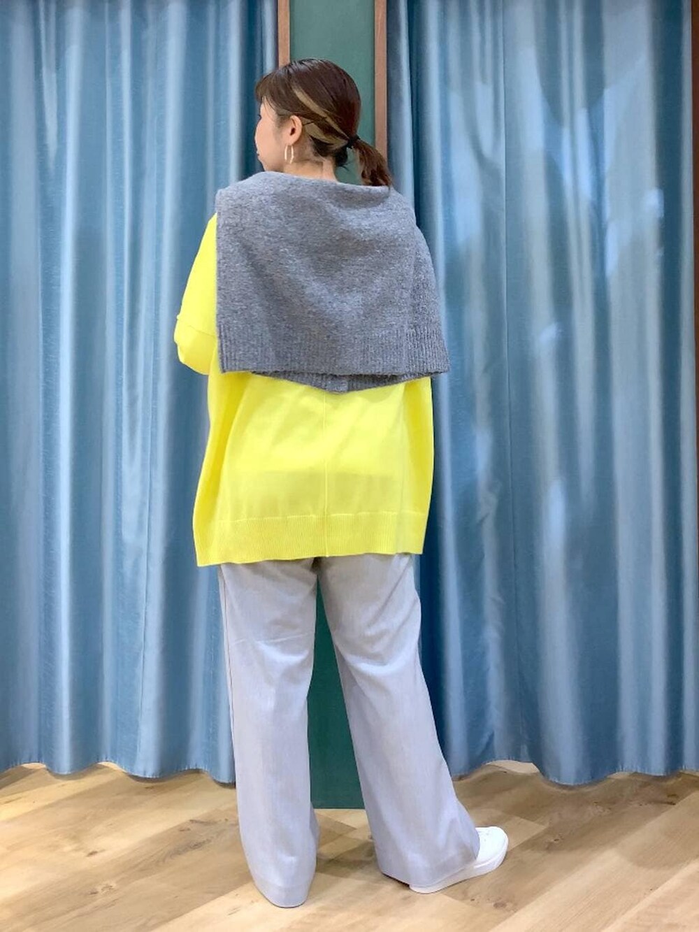 グレー系のカーディガン/ボレロ、ホワイト系のTシャツ/カットソー、イエロー系のニット/セーターを着用したレディースの秋コーディネートの3枚目の写真