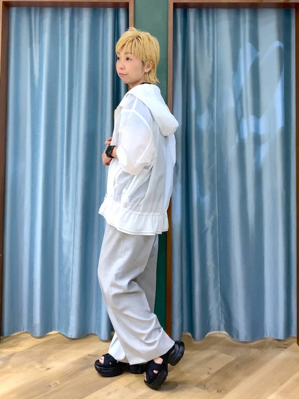 ブルー系のTシャツ/カットソー、ブラック系のサンダル、ホワイト系のブルゾンを着用したレディースの夏コーディネートの6枚目の写真