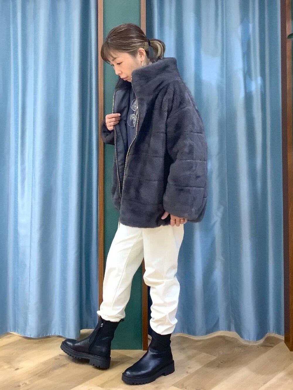 ブラック系のブーツ、グレー系のブルゾン、ホワイト系のその他パンツを着用したレディースの秋コーディネートの2枚目の写真