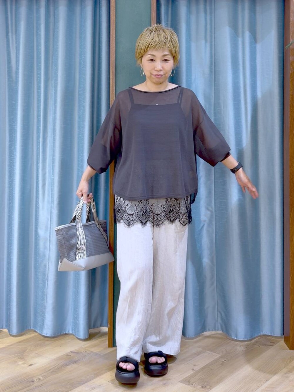 グレー系のトートバッグ、ブラック系のキャミソール、ベージュ系のその他パンツを着用したレディースの夏コーディネートの3枚目の写真