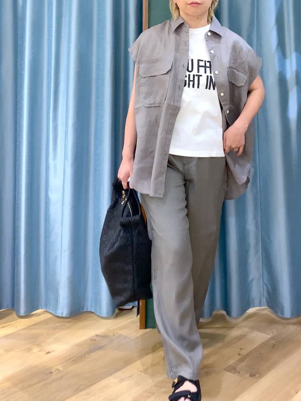 グレー系のその他パンツ、ホワイト系のTシャツ/カットソー、ブラック系のサンダルを着用したレディースの夏コーディネートの6枚目の写真