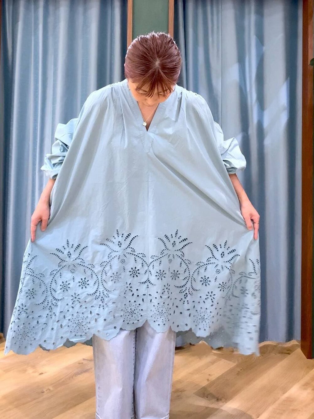 ブルー系のデニムパンツ、ベージュ系のスリッポン、グリーン系のワンピースを着用したレディースの春コーディネートの9枚目の写真