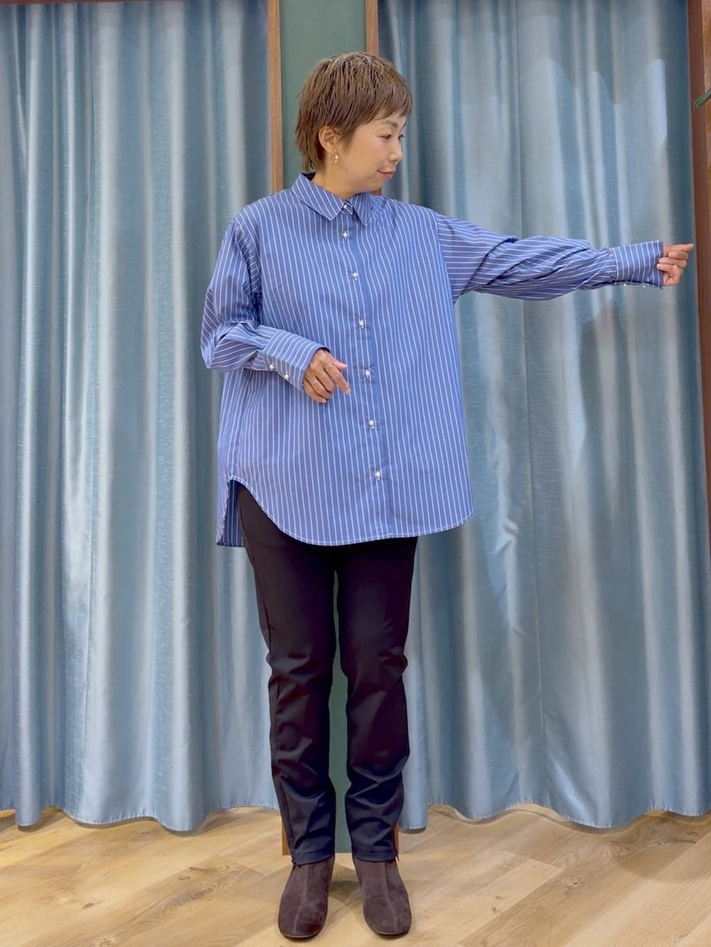 ブラック系のその他パンツ、ブラウン系のブーツ、ブルー系のシャツ/ブラウスを着用したレディースの秋コーディネートの8枚目の写真