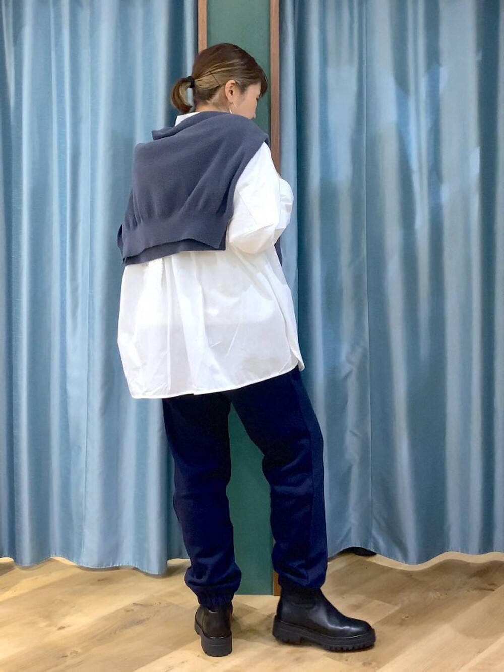 ブラック系のブーツ、ホワイト系のシャツ/ブラウス、グレー系のニット/セーターを着用したレディースの秋コーディネートの3枚目の写真