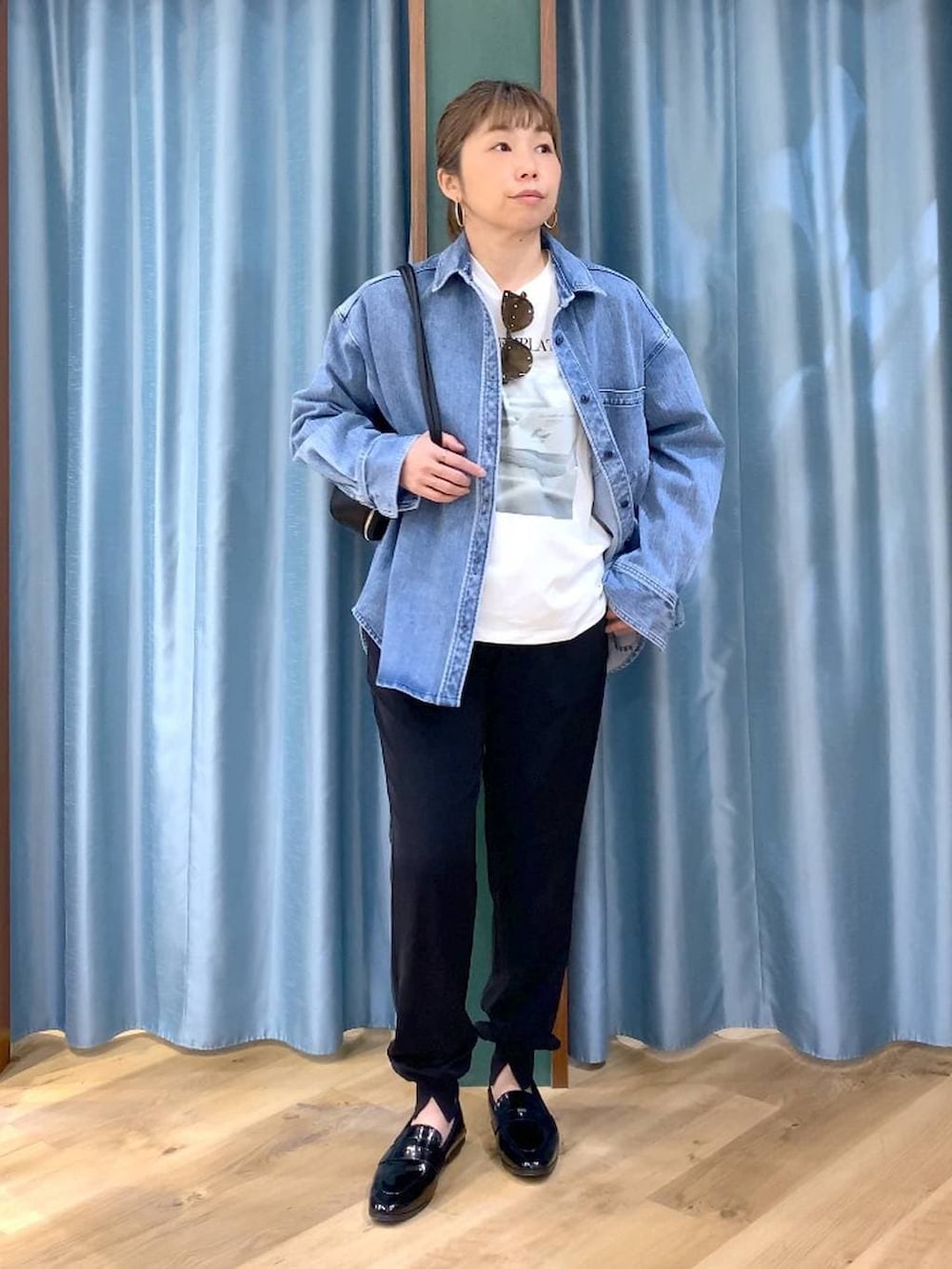 ブルー系のシャツ/ブラウス、ホワイト系のTシャツ/カットソー、ブラック系のハンドバッグを着用したレディースの春コーディネートの2枚目の写真