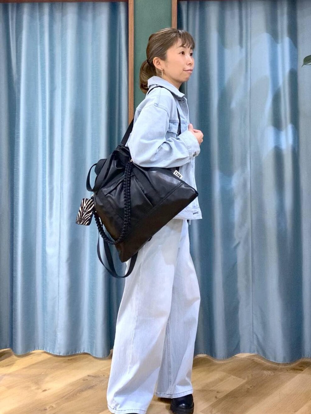 ブラック系のブーツ、ブラック系のバックパック/リュック、ブルー系のデニムパンツを着用したレディースの冬コーディネートの2枚目の写真