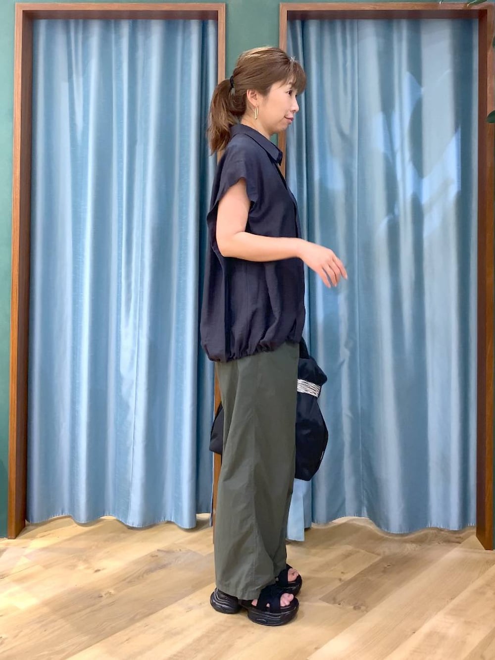 グリーン系のその他パンツ、ブラック系のトートバッグ、グレー系のシャツ/ブラウスを着用したレディースの春コーディネートの3枚目の写真