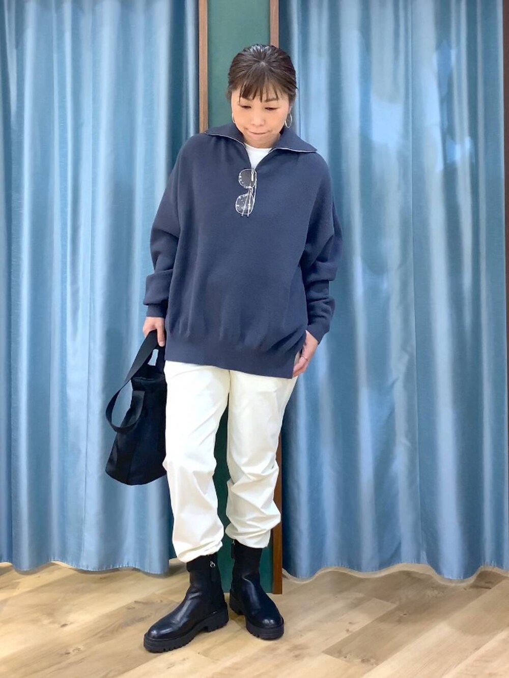 ブラック系のブーツ、ブラック系のショルダーバッグ、ホワイト系のその他パンツを着用したレディースの秋コーディネートの5枚目の写真