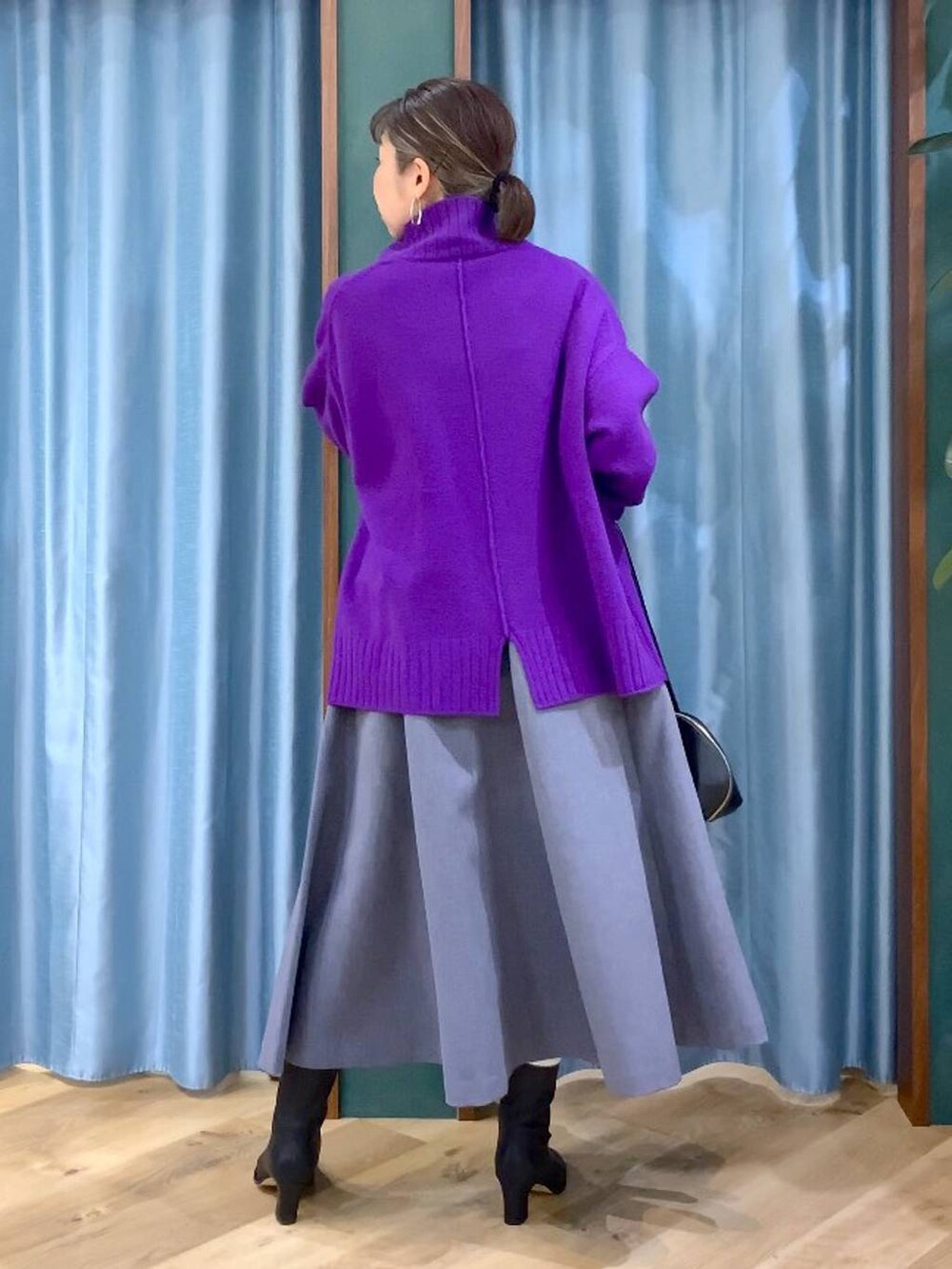 ブラック系のトートバッグ、グレー系のスカート、ブラック系のブーツを着用したレディースの秋コーディネートの5枚目の写真