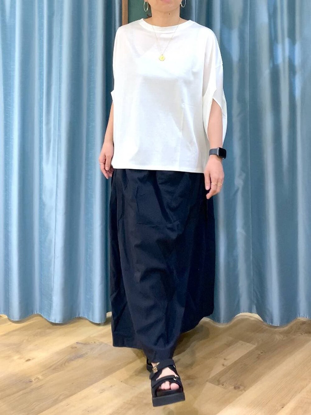 ホワイト系のTシャツ/カットソー、ブラック系のスカート、ブラック系のサンダルを着用したレディースの春コーディネートの6枚目の写真
