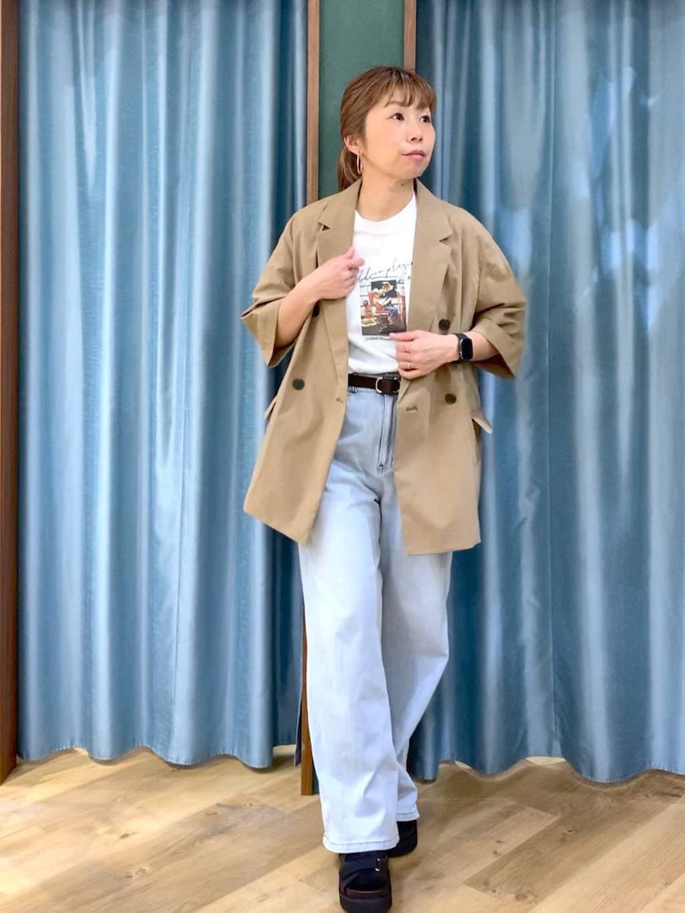 ブルー系のデニムパンツ、ホワイト系のTシャツ/カットソー、ブラウン系のサンダルを着用したレディースの春コーディネートの4枚目の写真