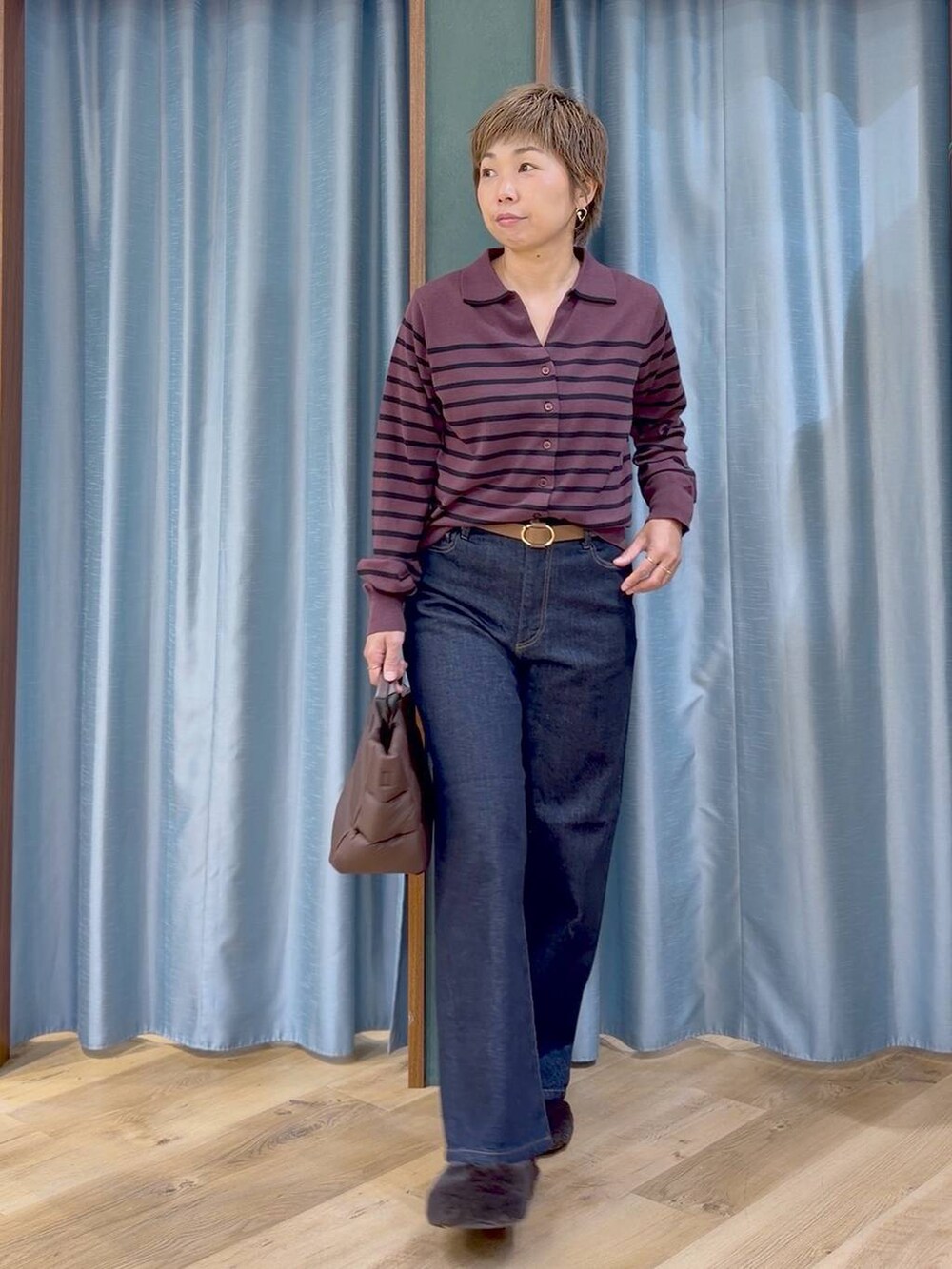 ブラウン系のその他シューズ、ブラウン系のトートバッグ、ブルー系のデニムパンツを着用したレディースの秋コーディネートの8枚目の写真