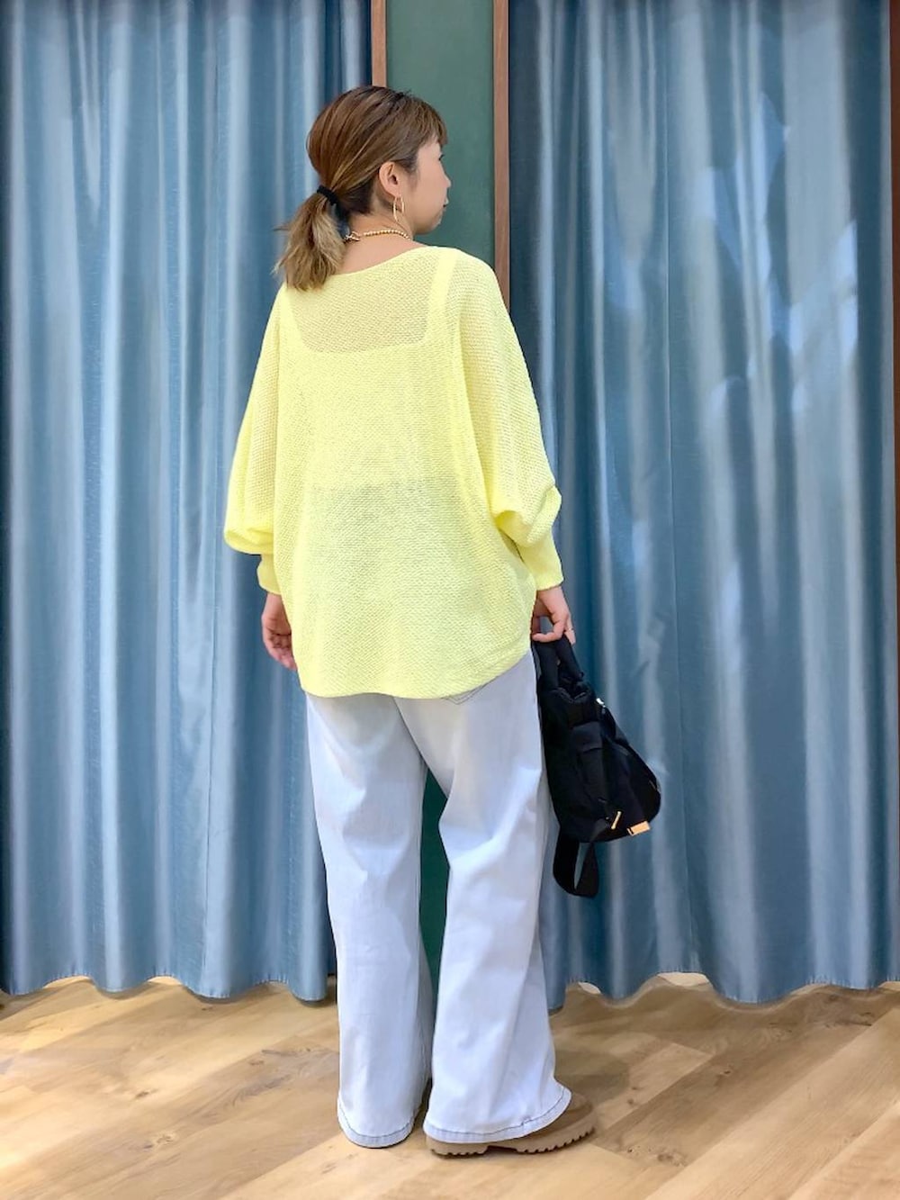 ブラック系のショルダーバッグ、ベージュ系のローファー、ブルー系のデニムパンツを着用したレディースの春コーディネートの5枚目の写真