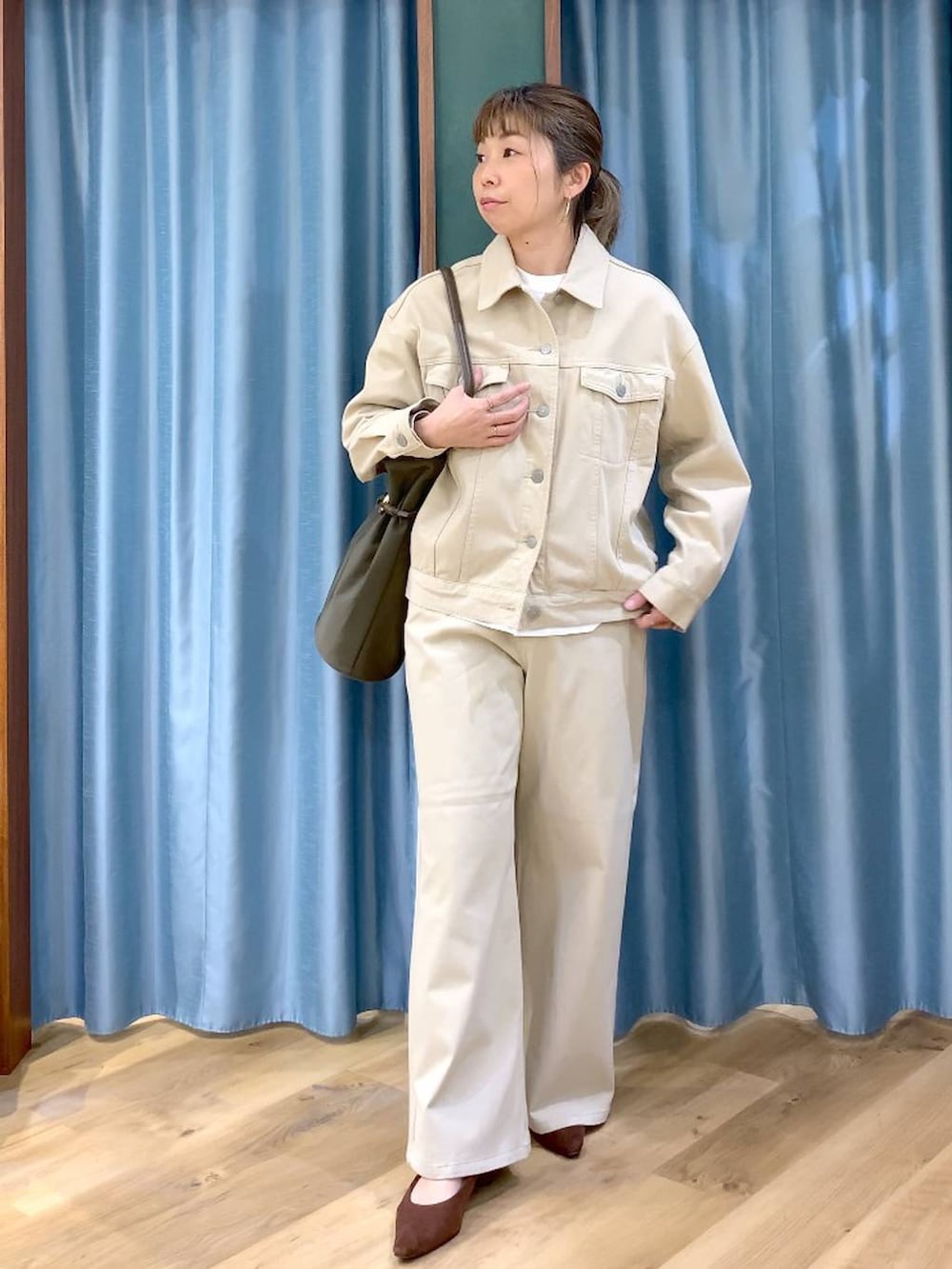 ブラウン系のパンプス、ベージュ系のデニムパンツ、ベージュ系のデニムジャケットを着用したレディースの春コーディネートの4枚目の写真