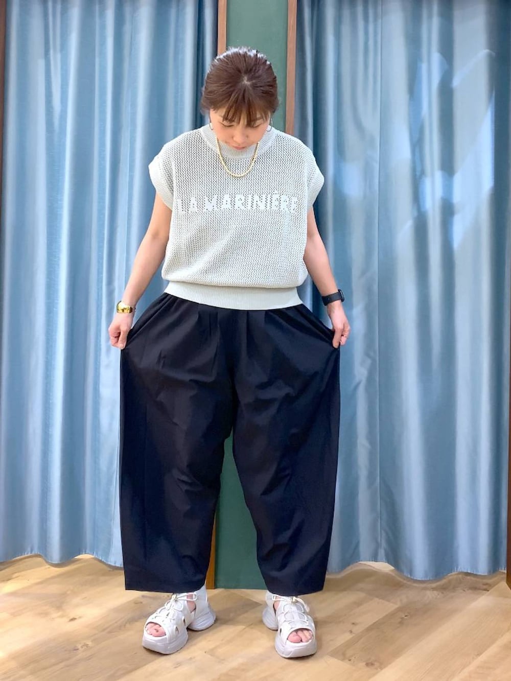 ブラック系のTシャツ/カットソー、グリーン系のニット/セーター、ブラック系のその他パンツを着用したレディースの春コーディネートの7枚目の写真