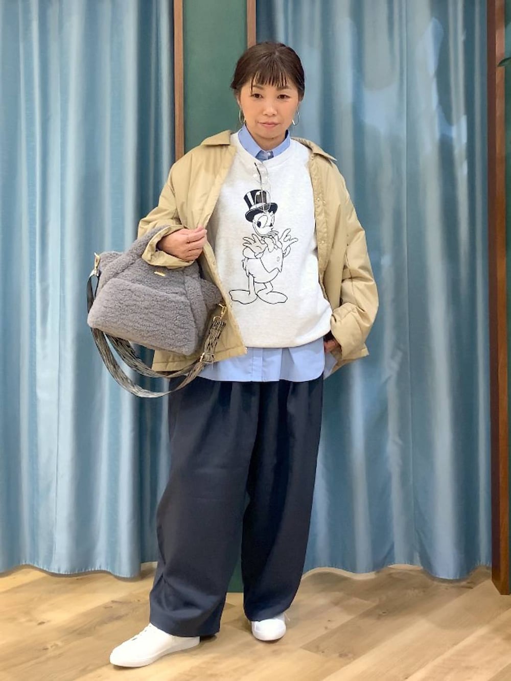 ベージュ系のブルゾン、ブルー系のシャツ/ブラウス、グレー系のスラックスを着用したレディースの秋コーディネートの3枚目の写真