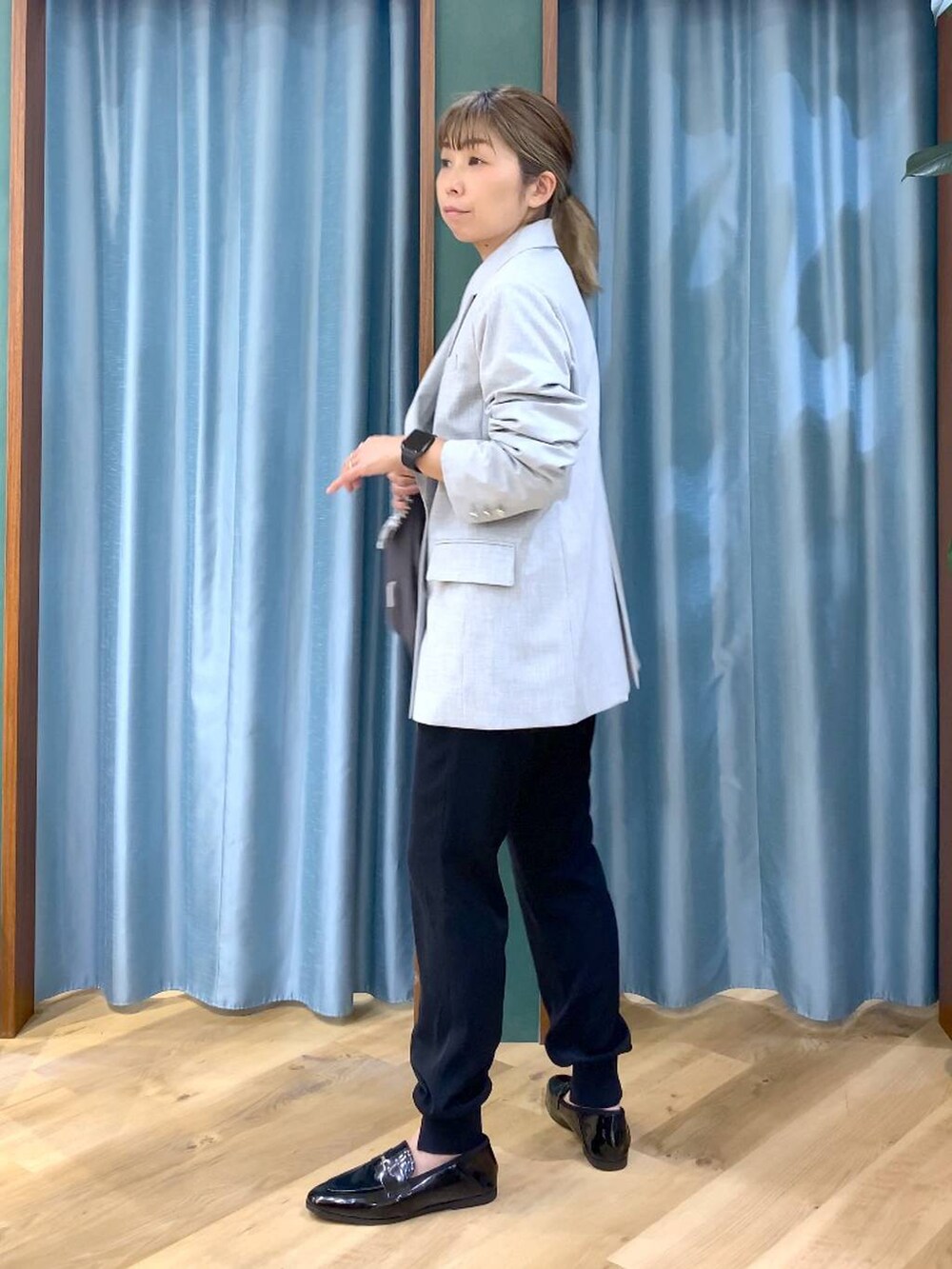 グレー系のショルダーバッグ、ホワイト系のTシャツ/カットソー、グレー系のテーラードジャケットを着用したレディースの冬コーディネートの4枚目の写真