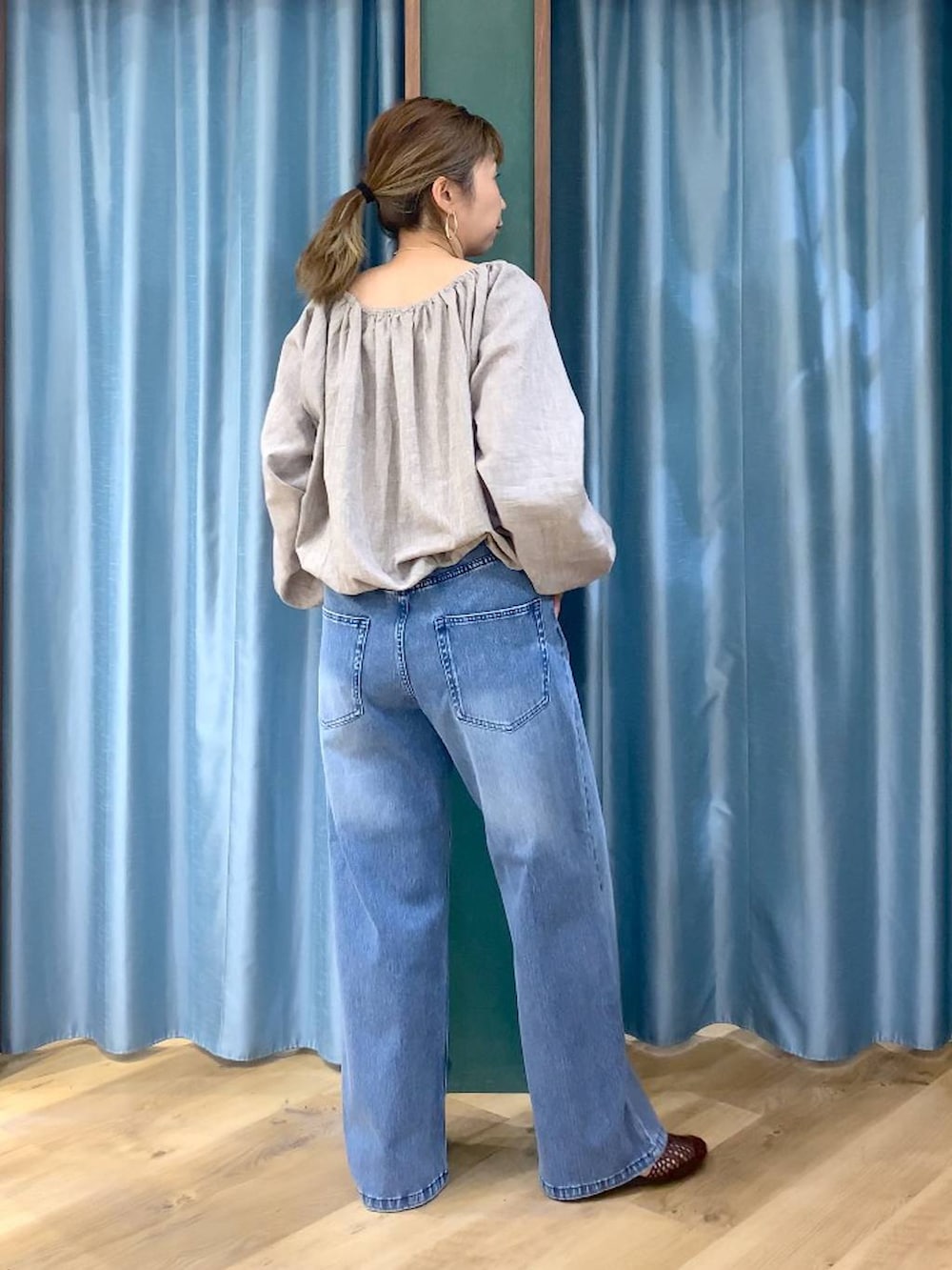 ブルー系のデニムパンツ、ベージュ系のシャツ/ブラウス、ブラウン系のスリッポンを着用したレディースの春コーディネートの7枚目の写真